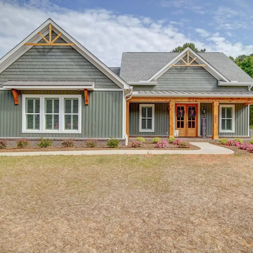 Custom craftsman home exterior with green siding, wood accents, and covered porch