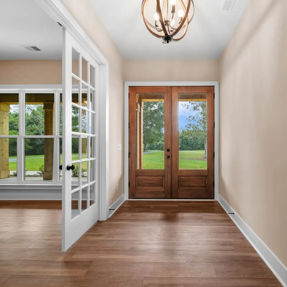Spacious entryway with Mahogany double doors and glass french doors.