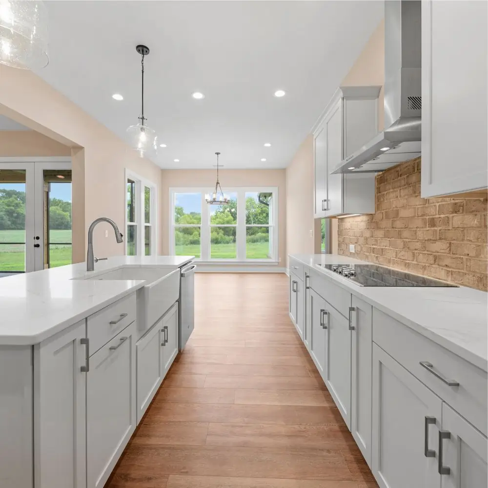 Farmhouse kitchen with brick backsplash and white cabinetry