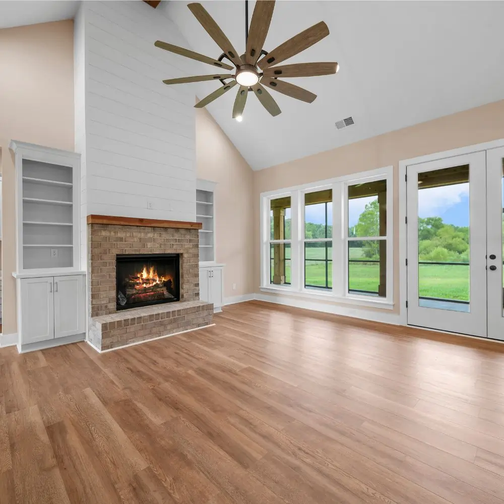 Cozy fireplace in large living area with white built in bookshelves.