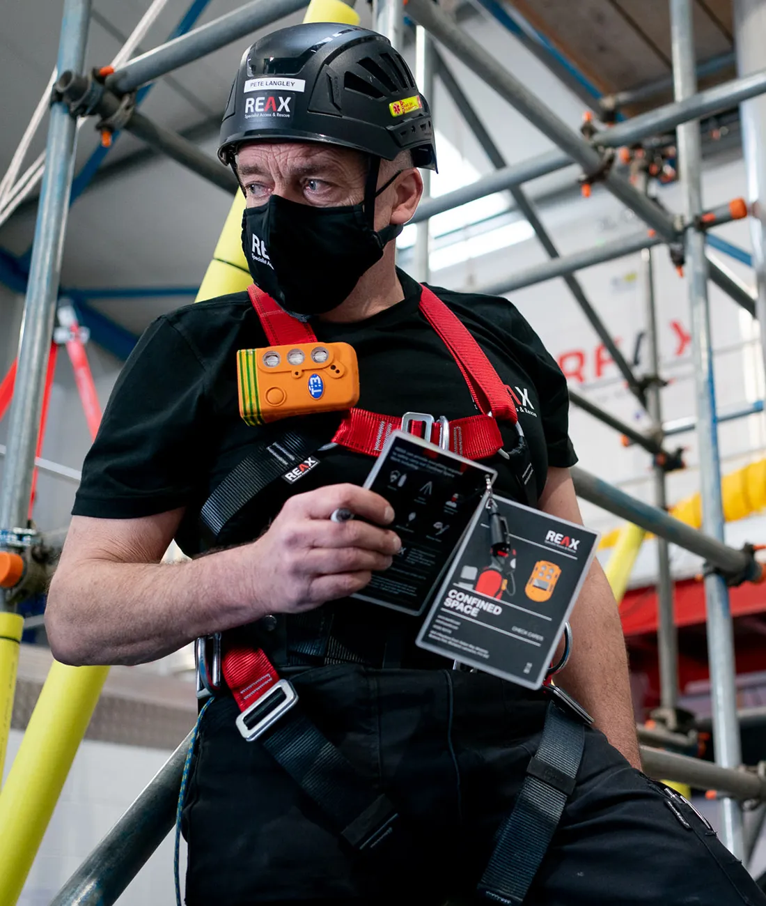 Confined Space Entrant at REAX holding Confined Space Check Cards