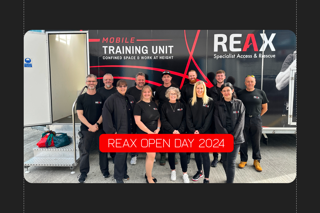 A group of people wearing matching black shirts pose in front of a mobile training unit with text "REAX Open Day 2024”