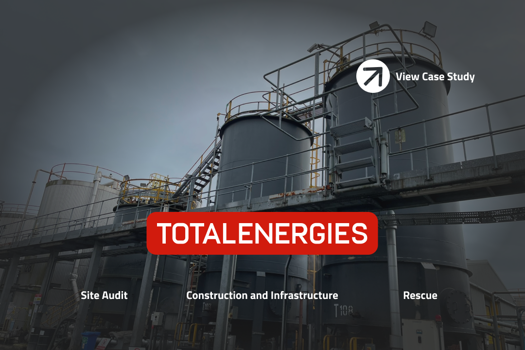 Silo tanks with a grey sky and the words TotalEnergies