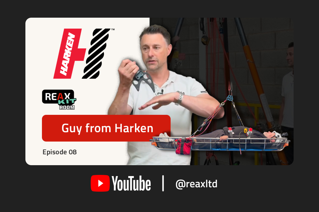 Man holding a piece of equipment for rescue. Another man suspended in a stretcher wearing safety equipment