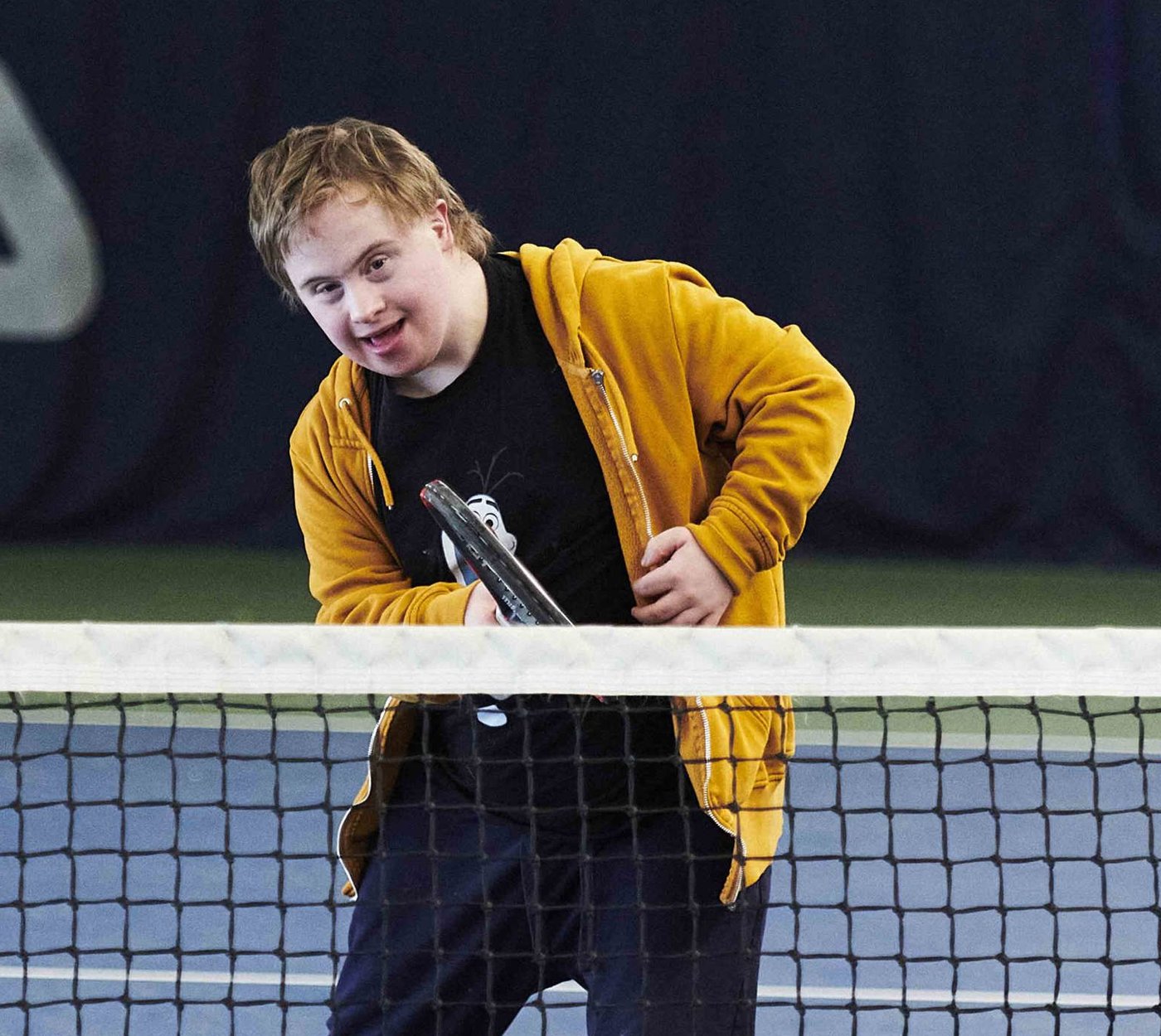 A player enjoying an adapted tennis session at the net