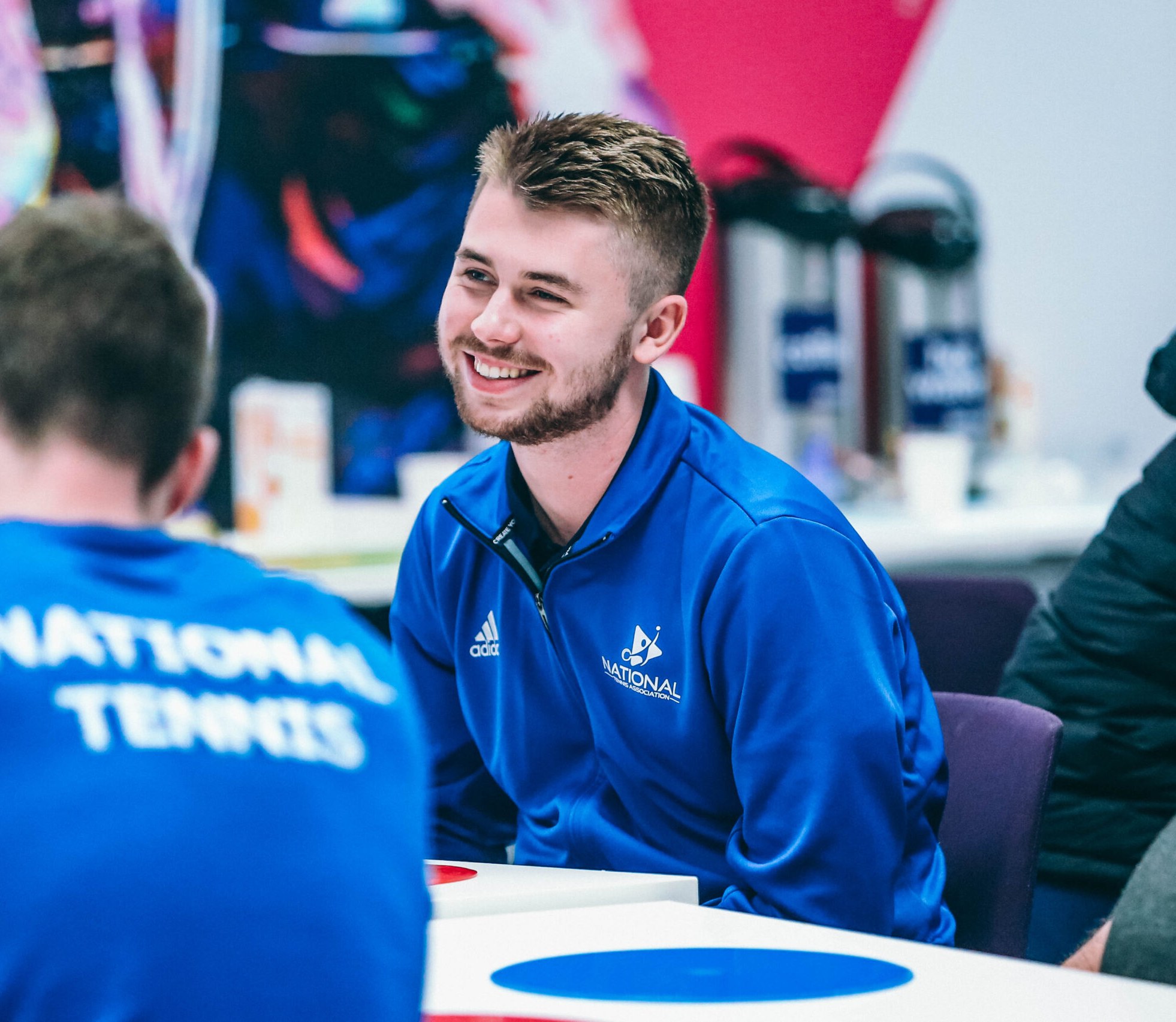 A National Tennis coach in conversation at a team day