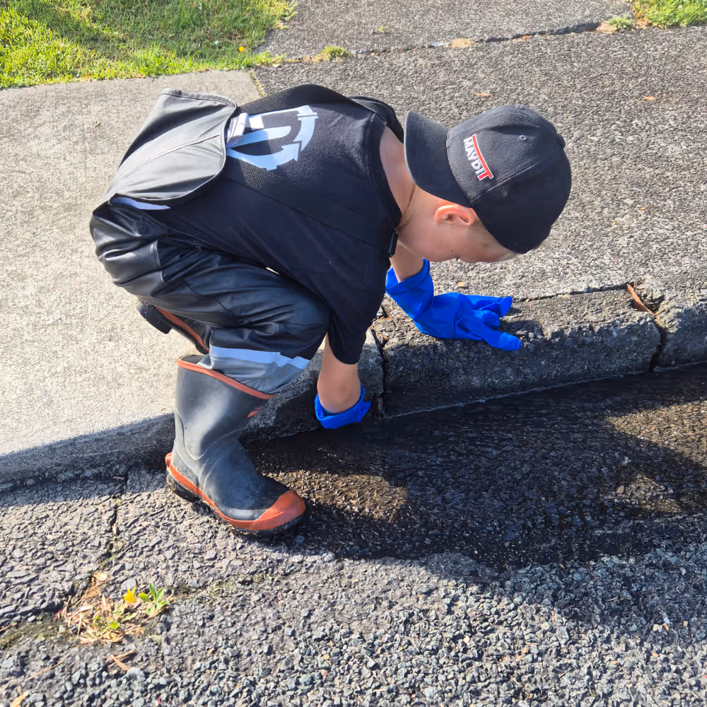 Young boy fixing drain. 