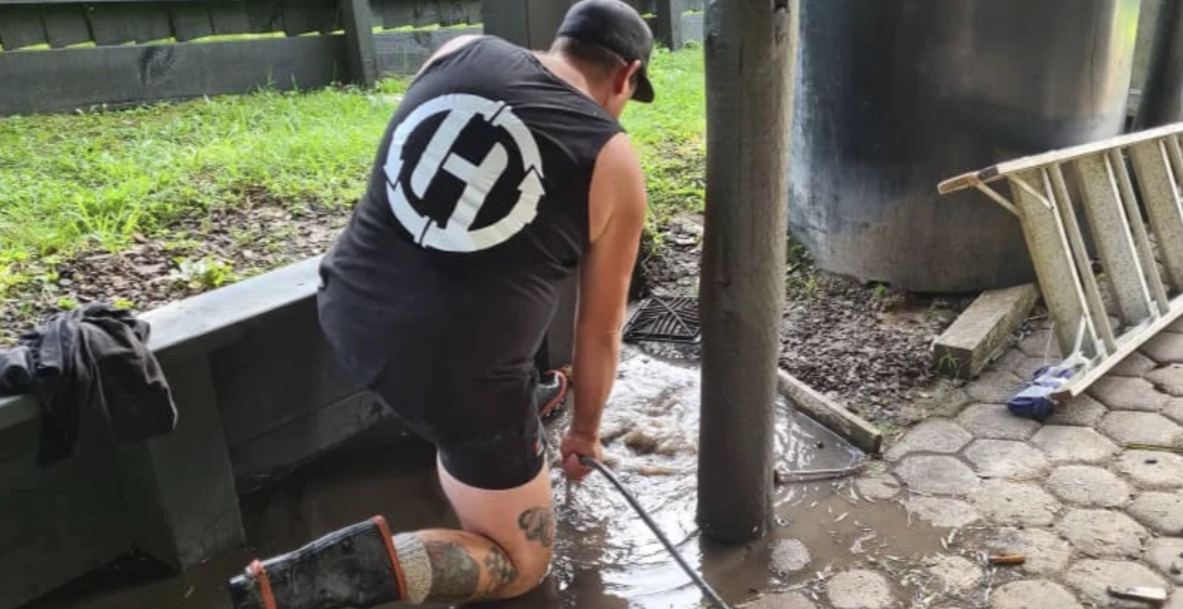 Hydro Vision technician clearing a flooded outdoor drain