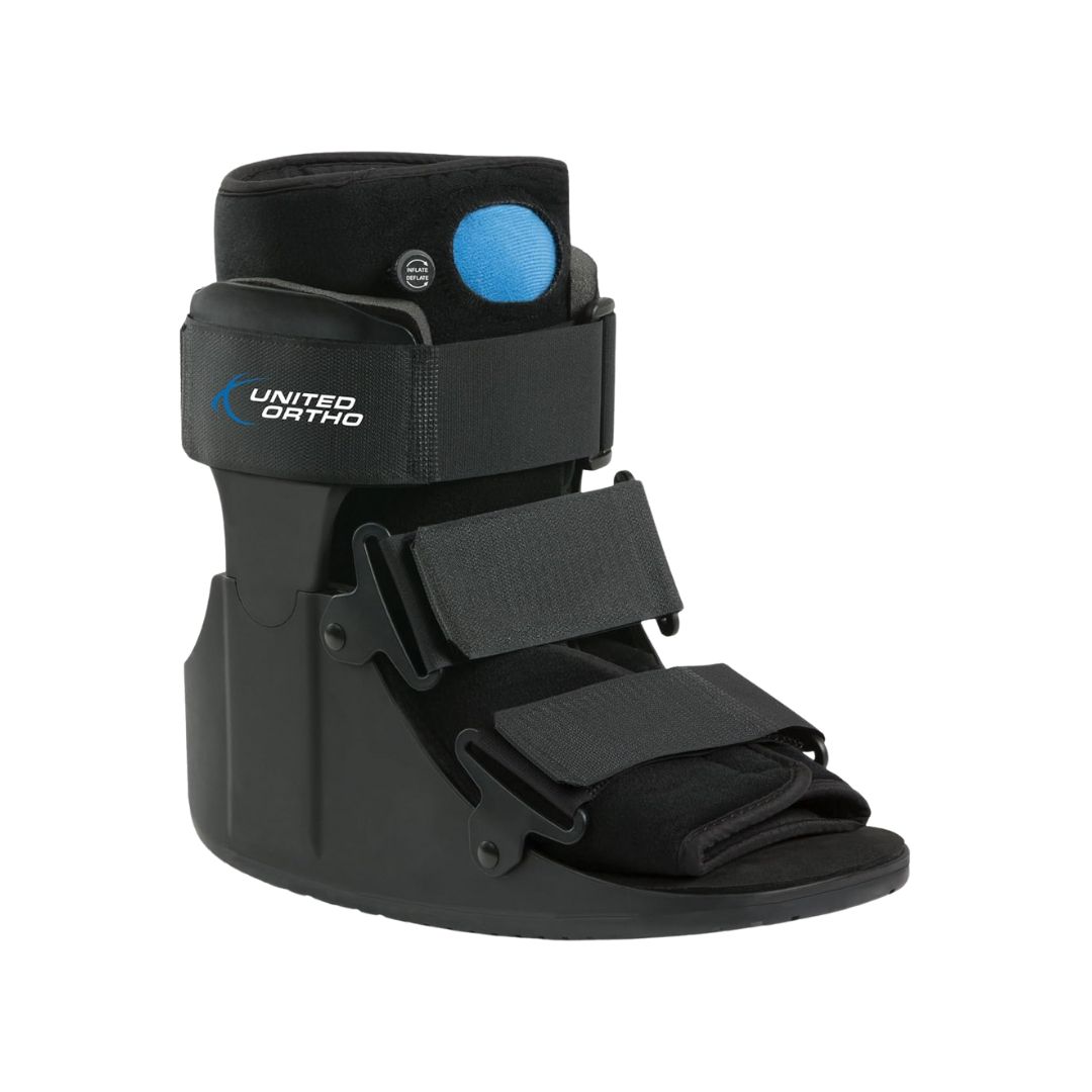 A black medical walking boot with sturdy plastic sides and a rocker sole, designed for ankle injuries or post-op support.