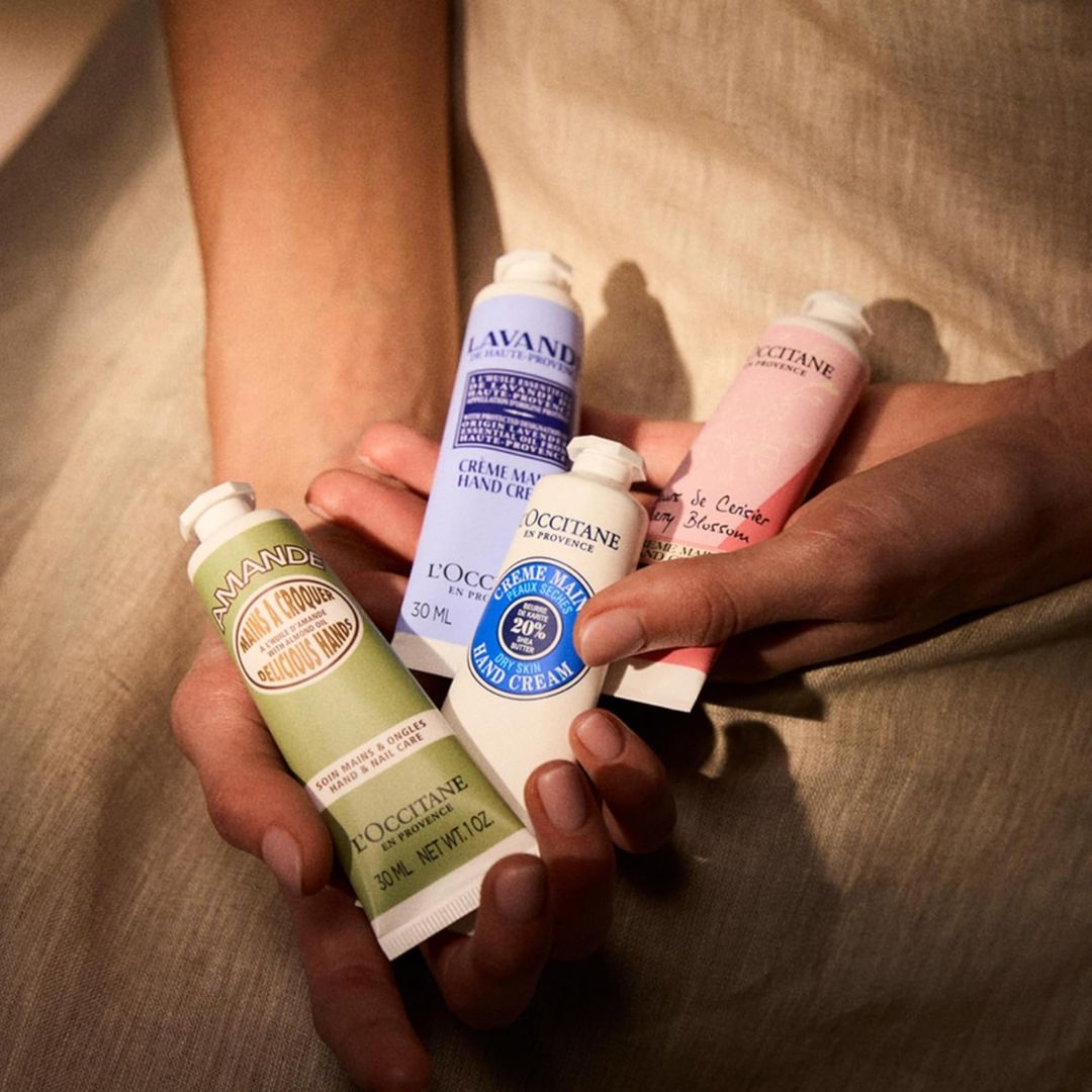 A set of travel-size hand creams in colorful tubes, displayed together in festive holiday packaging.