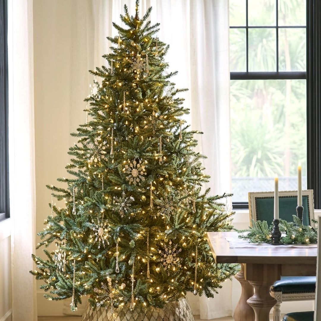 A full, traditional artificial Christmas tree with dense blue-green needles, shown in various sizes and lighting options.