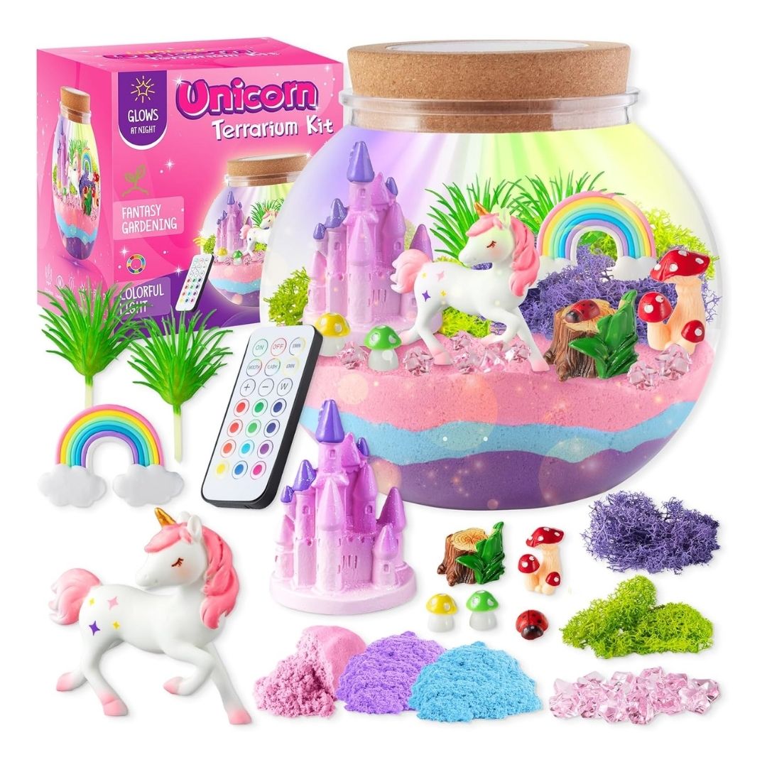 A DIY unicorn light-up terrarium kit with a clear jar, miniature unicorn, castle, rainbow, sparkly crystals, and color-changing LED base.