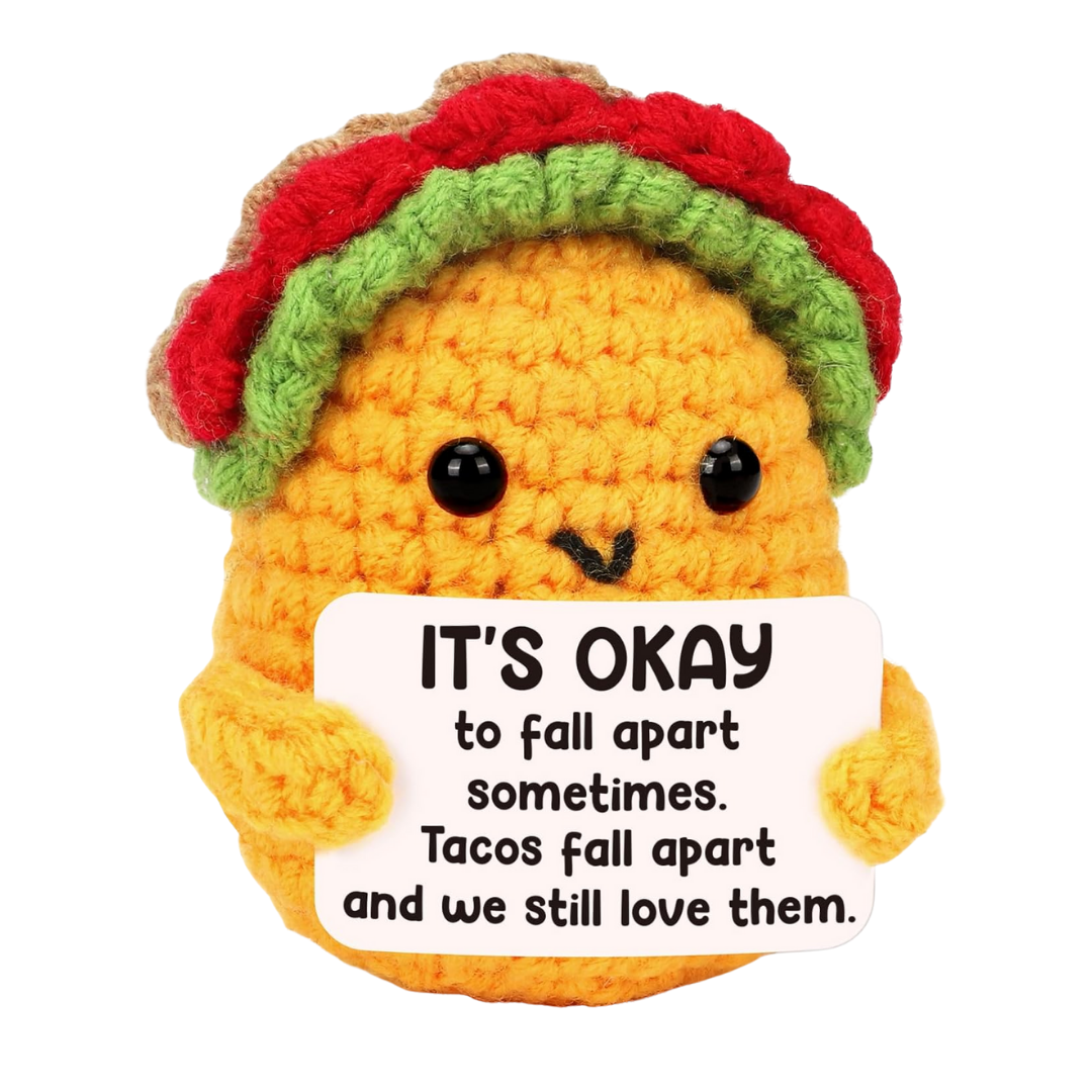 A small handmade crochet taco plush with a smiling face, designed as a cheerful desk or holiday decoration.