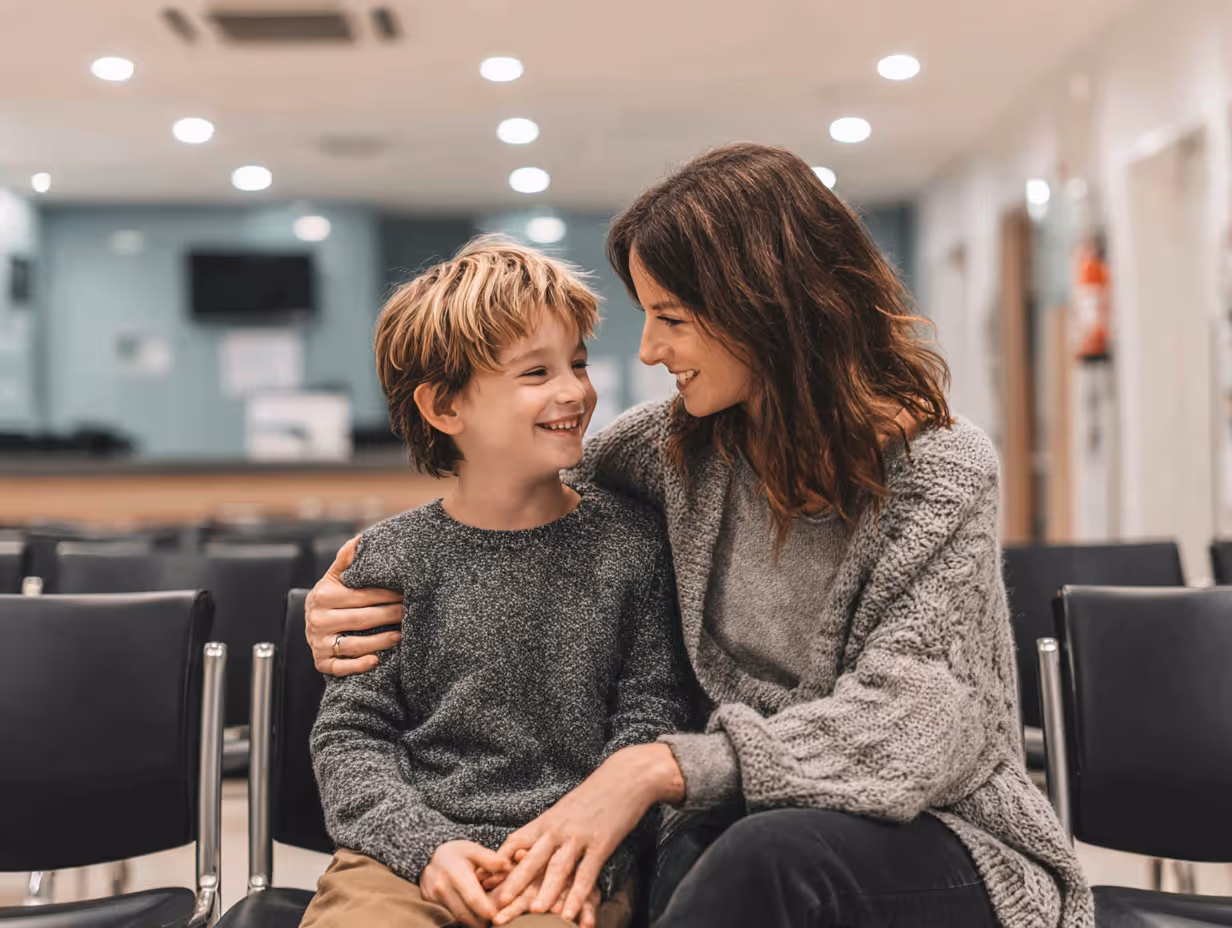 smiling young boy with his mother in a clinic waiting room