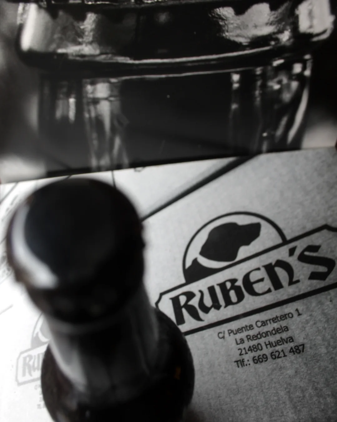Botella sobre un papel con el logo de Rubens's y dirección en La Redondela, Huelva.