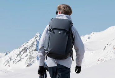 Hiker with a K&F Concept photography backpack in a mountain landscape