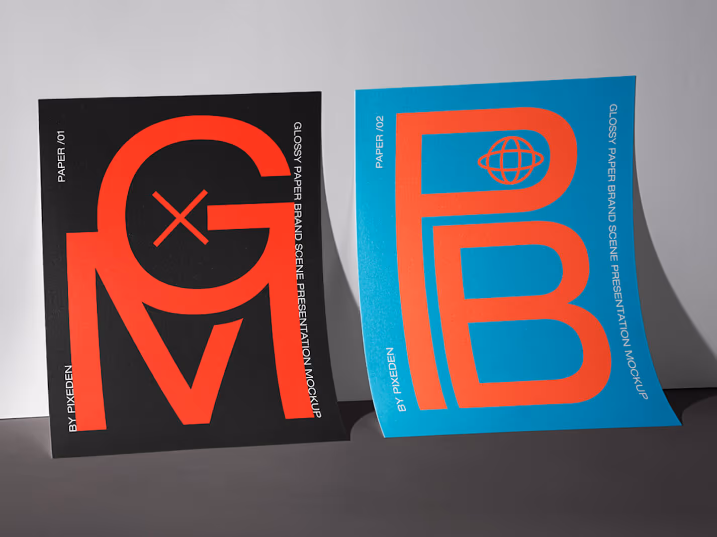 Two glossy paper mockups standing upright, one black with large red letters ‘GXV’ and one blue with large red letters ‘PB’ and a globe icon.