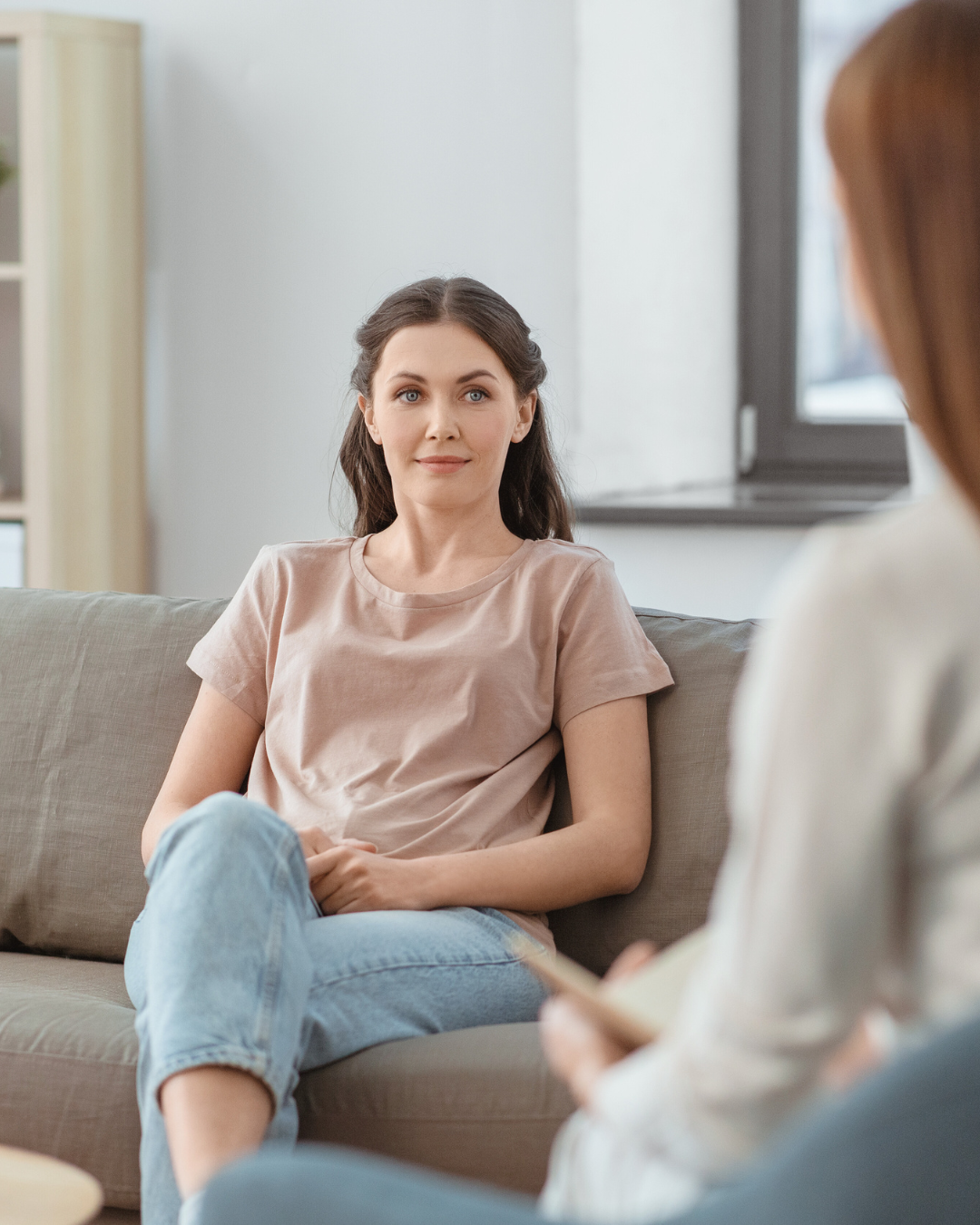 Psicóloga tomando notas durante sessão presencial.