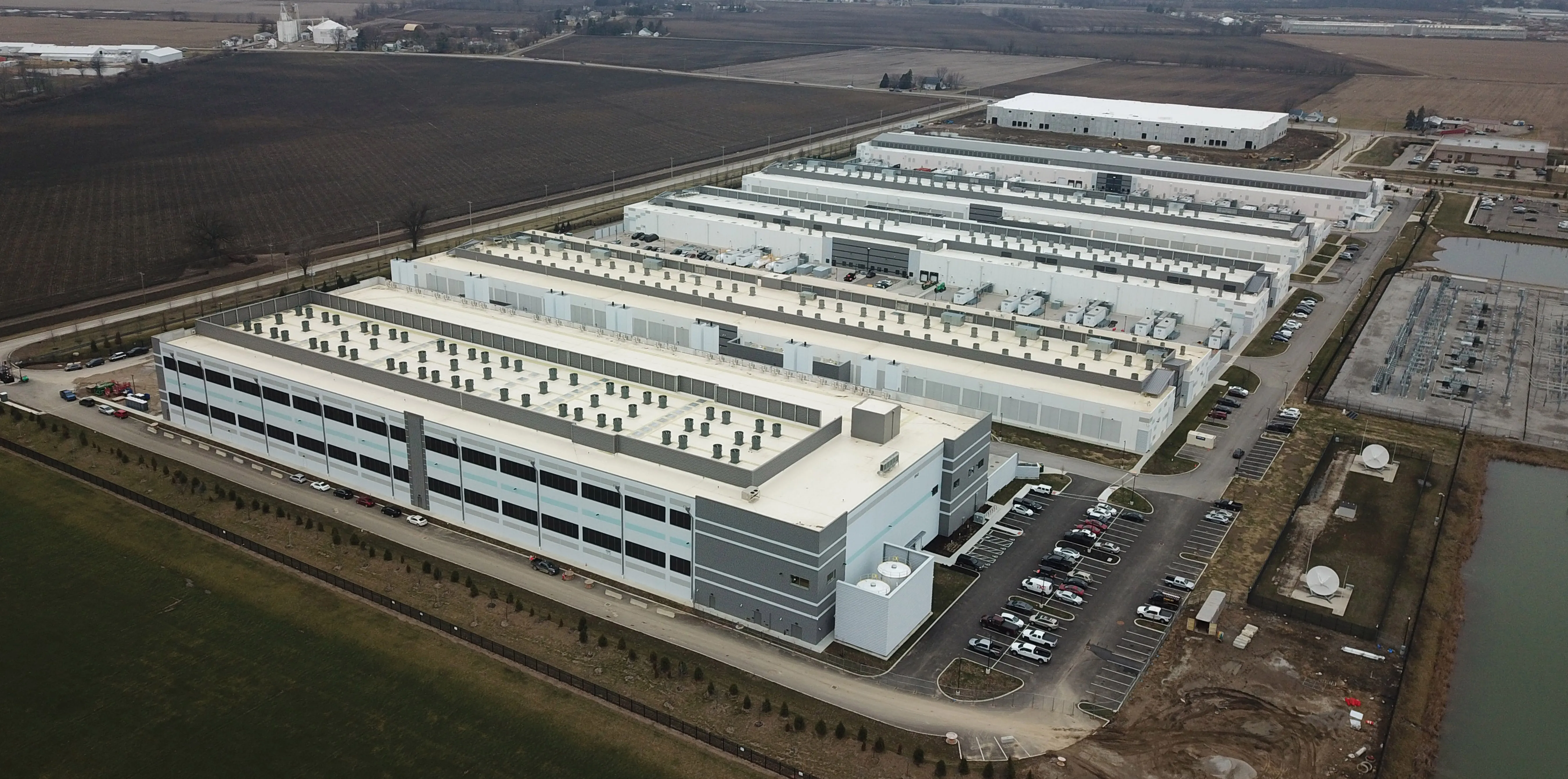 Aerial view of an Amazon Web Services data center campus with long, low buildings and rooftop equipment