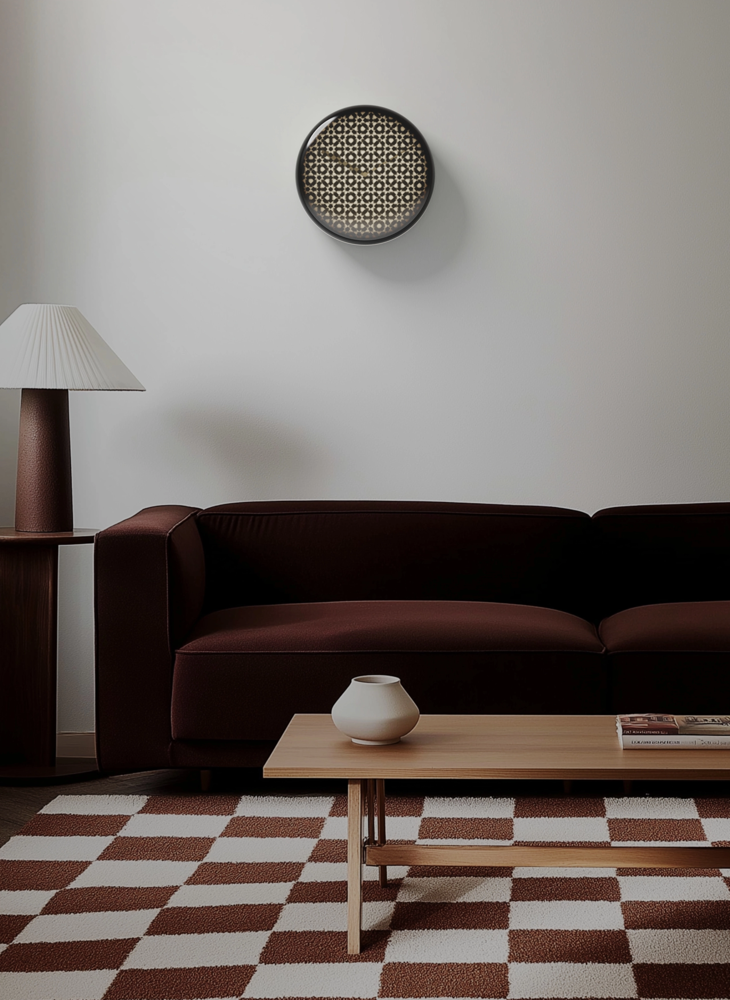 Minimalist living room with a dark brown sofa, wooden coffee table holding a white vase and a book, a white and brown checkered rug, a brown side table with a white pleated lamp, and a round wall clock with a geometric pattern.