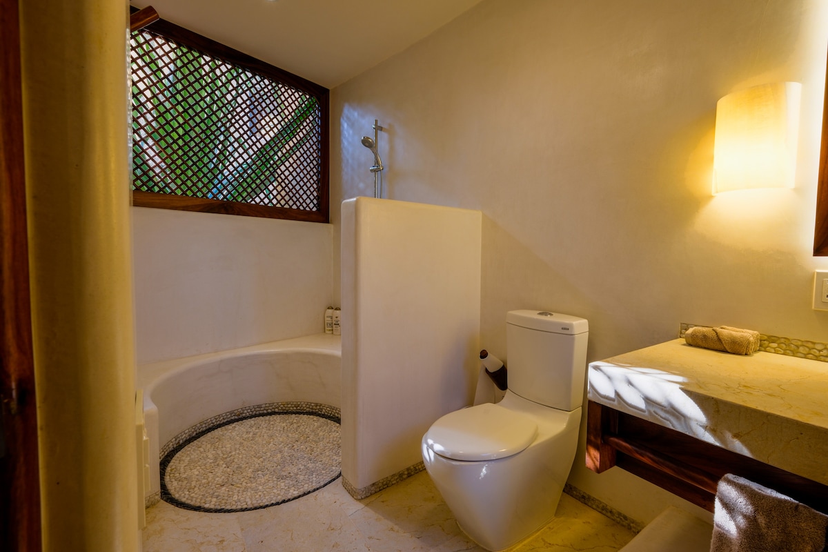 Open-air bathroom with a pebble floor