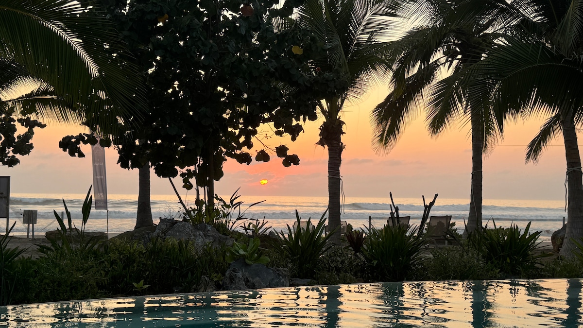 Shared pool framed by palms and tropical gardens