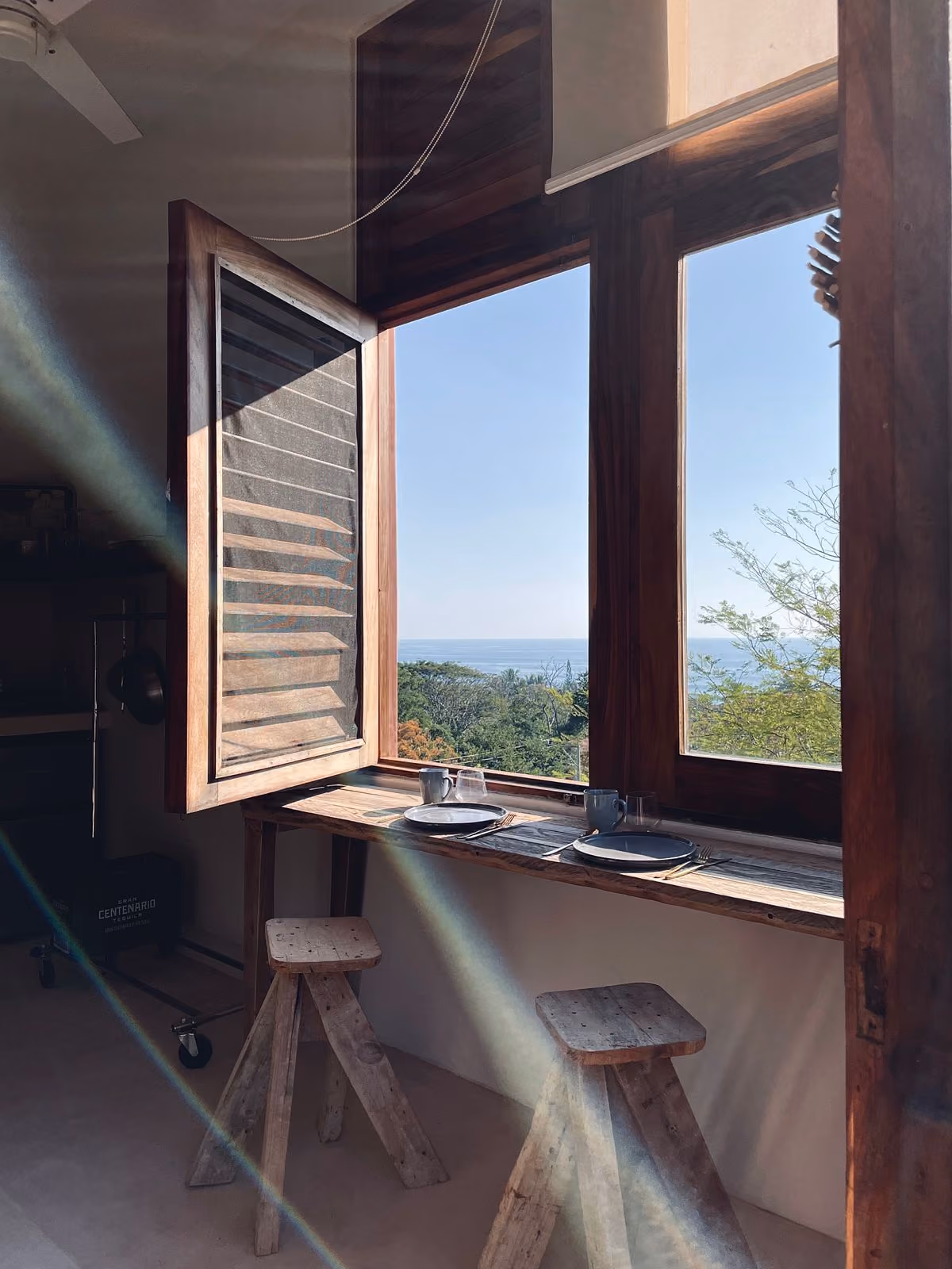 Workspace at the shuttered window looking over the forest to the sea