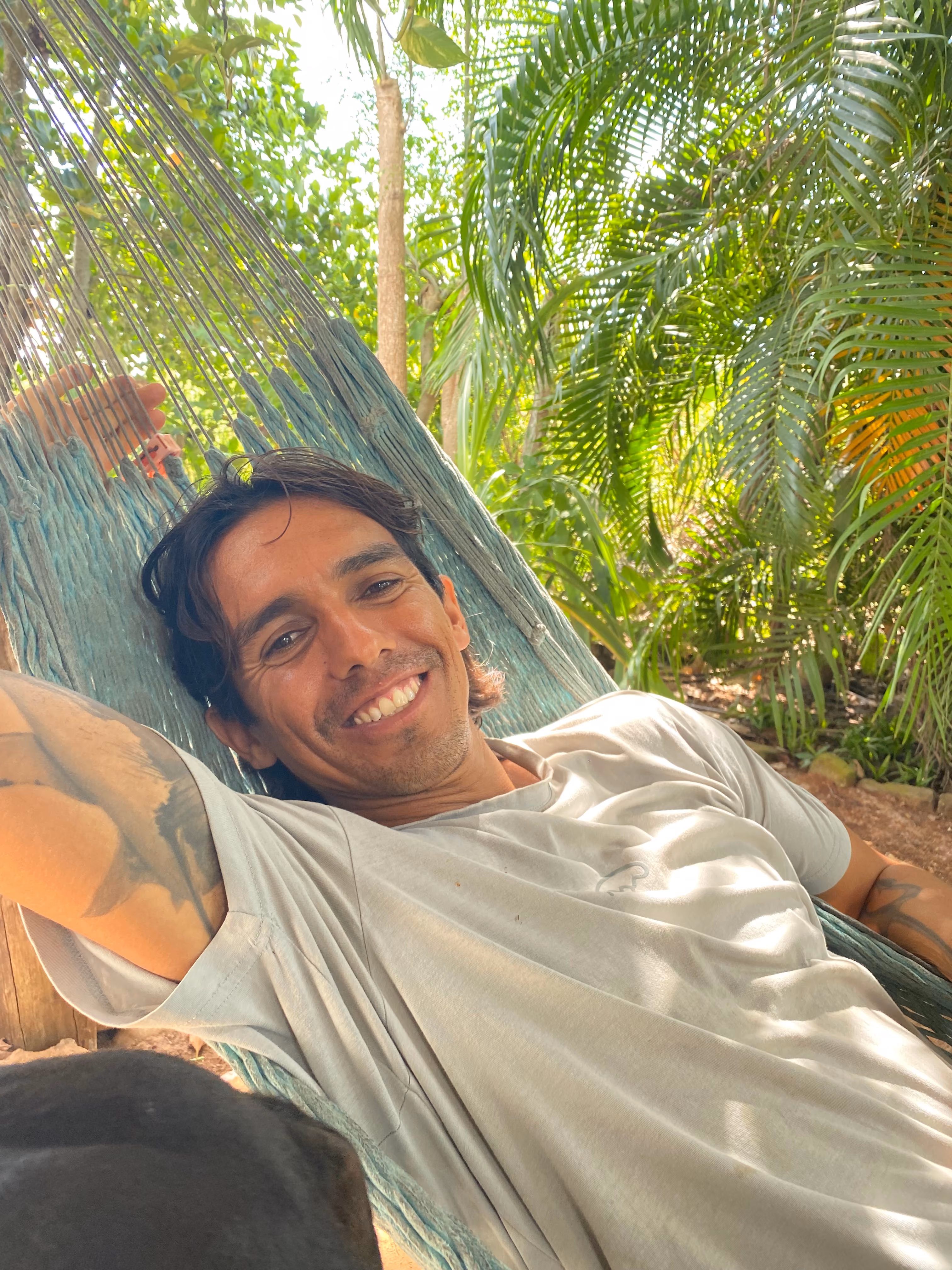 Cristo León sonriendo en una hamaca bajo las palmeras