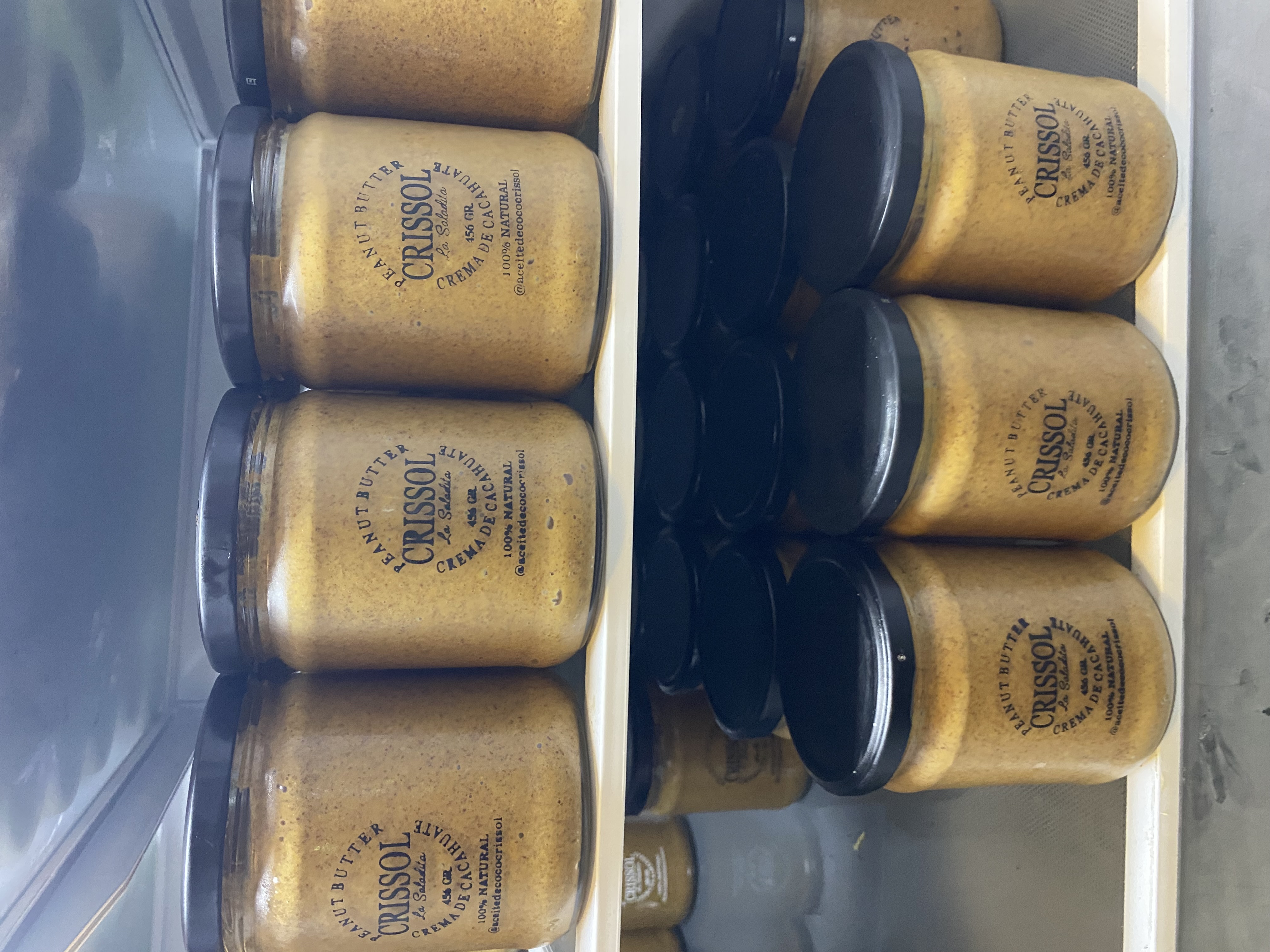 Rows of Crissol peanut butter jars on refrigerator shelves