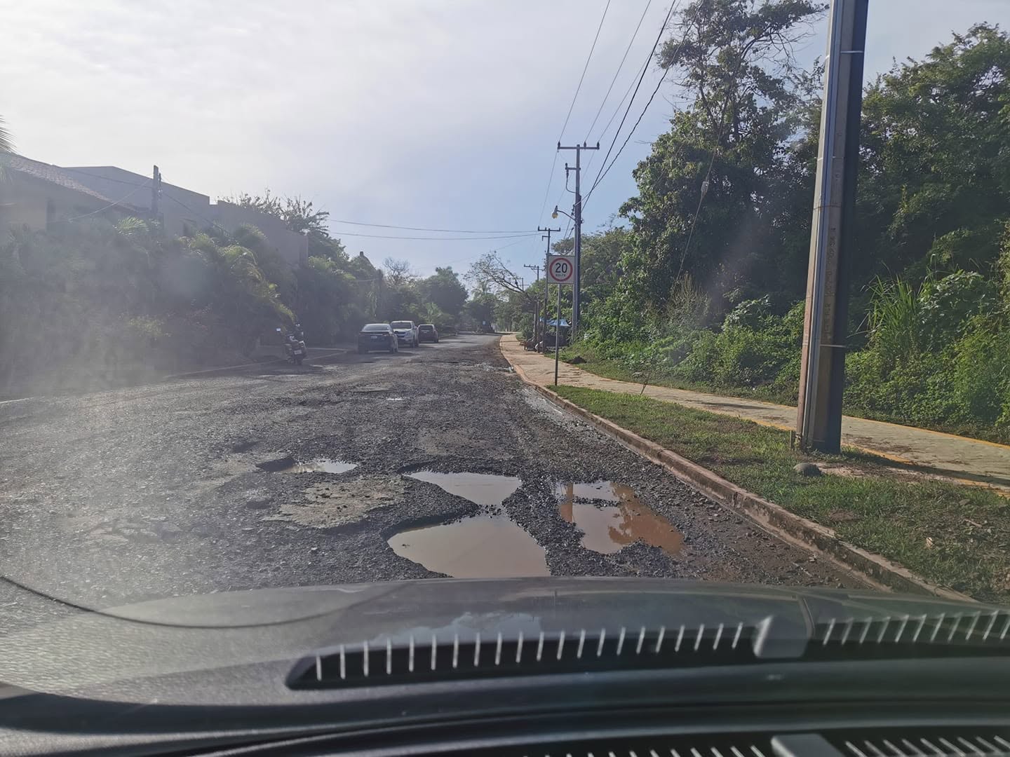Potholes filled with muddy water on a paved road