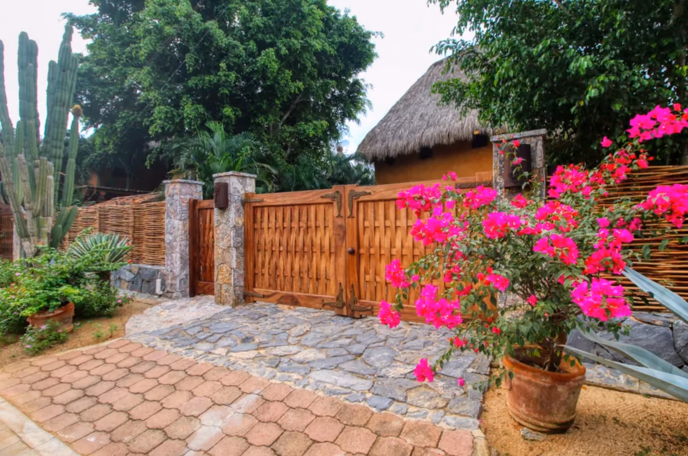 Entrance gate framed by bougainvillea at Villa Armonia