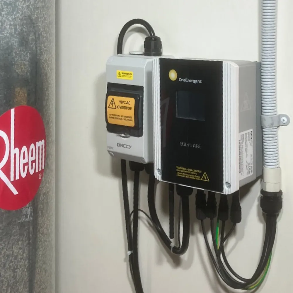 Wall-mounted solar energy controller with cables connected, next to a Rheem water heater tank.