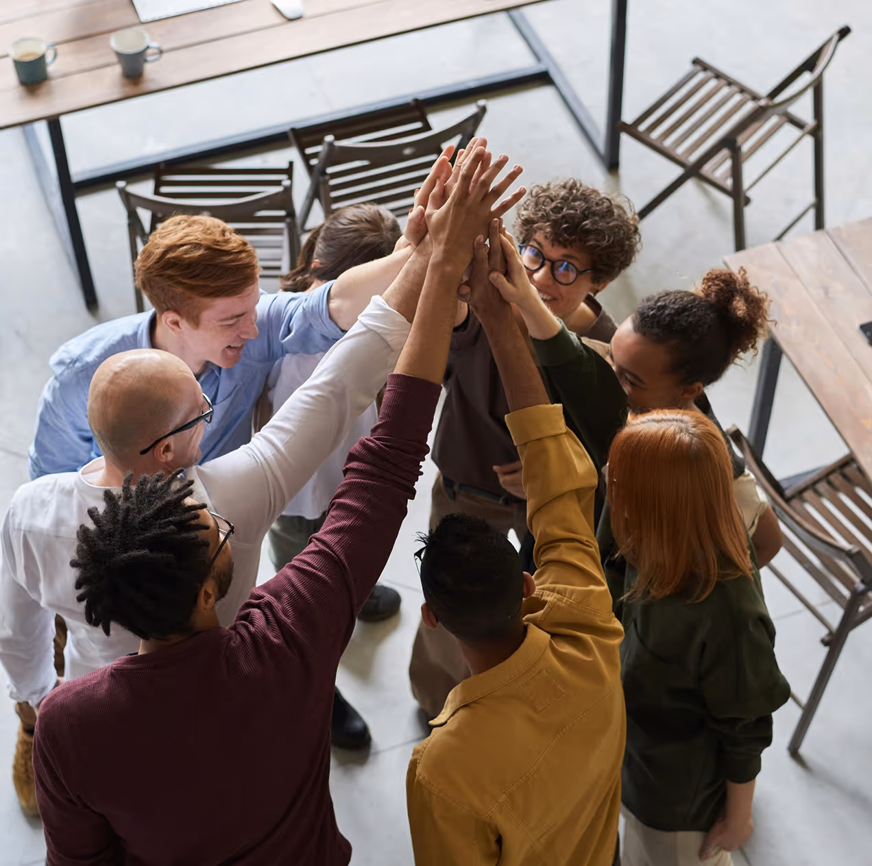 A group of diverse people are doing a high five together