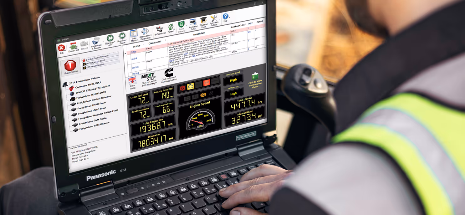 Technician using Noregon truck diagnostic software to check vehicle performance data.