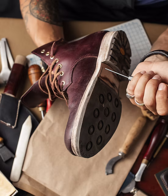 Shoemaker hands repairing shoe, close up.