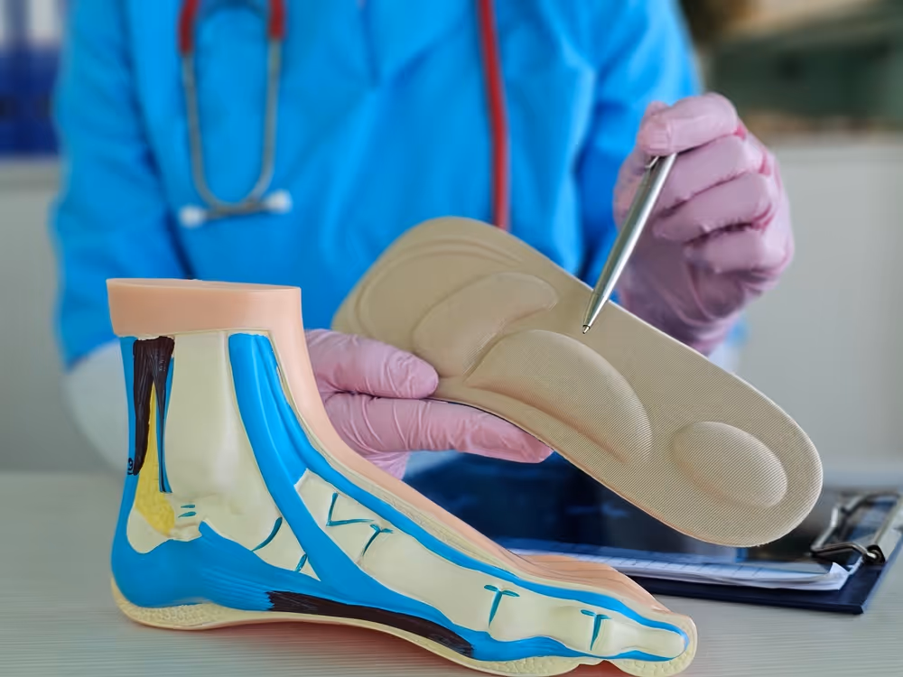 A doctor looking at structural diagrams of a foot