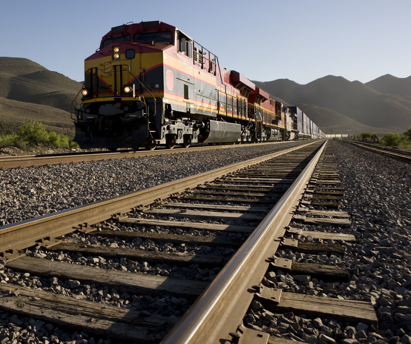 Intermodal container train on a transcontinental rail lane through mountain terrain