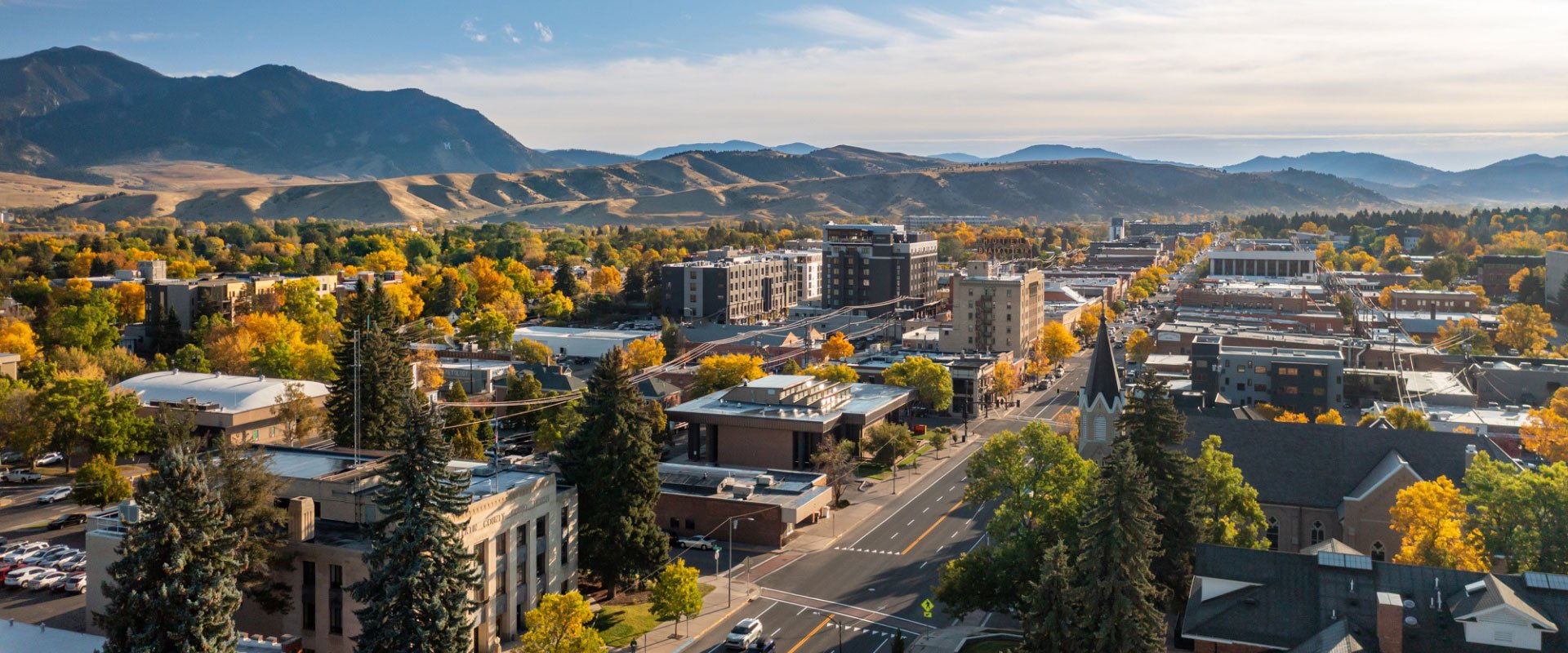 Aerial view of downtown Bozeman in fall with the Bridger Mountains rising behind the city, Montana