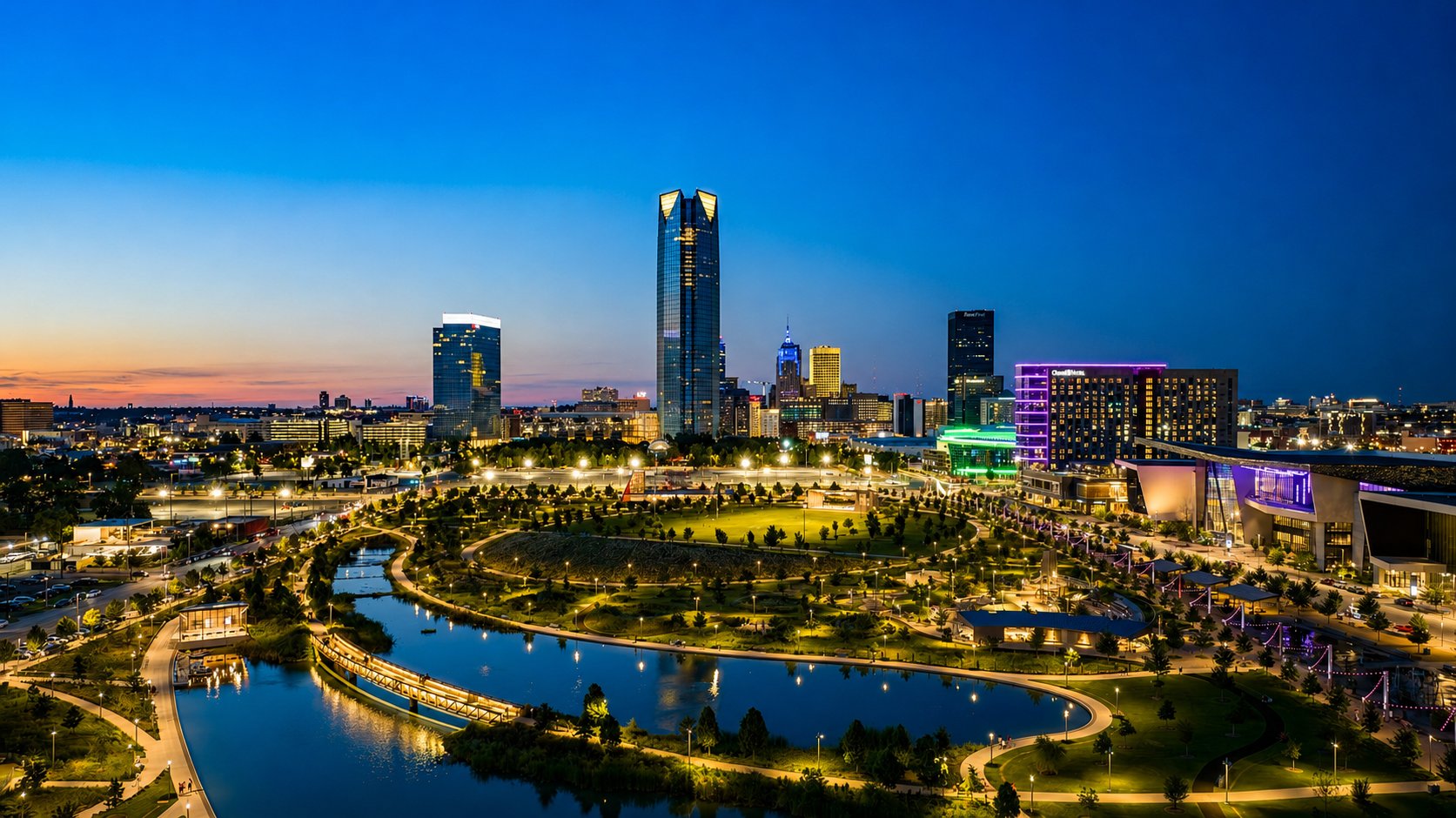 Oklahoma City skyline at dusk with Devon Tower rising above Scissortail Park and its lake, Oklahoma