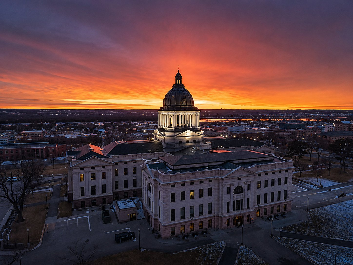 Aerial view of the South Dakota State Capitol with its lit dome at sunrise in Pierre, South Dakota