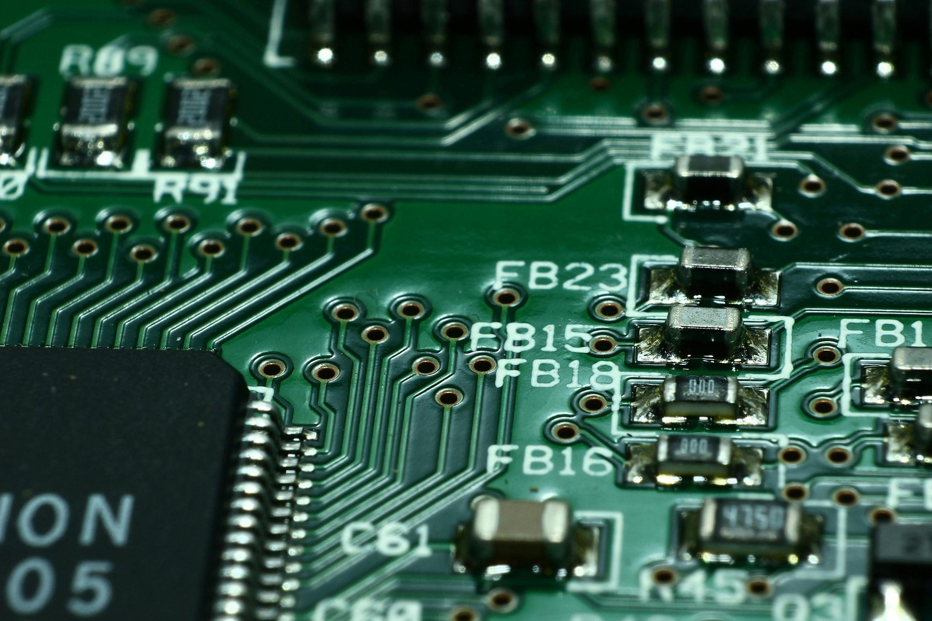 Macro view of a green printed circuit board with surface-mount components and an integrated circuit chip