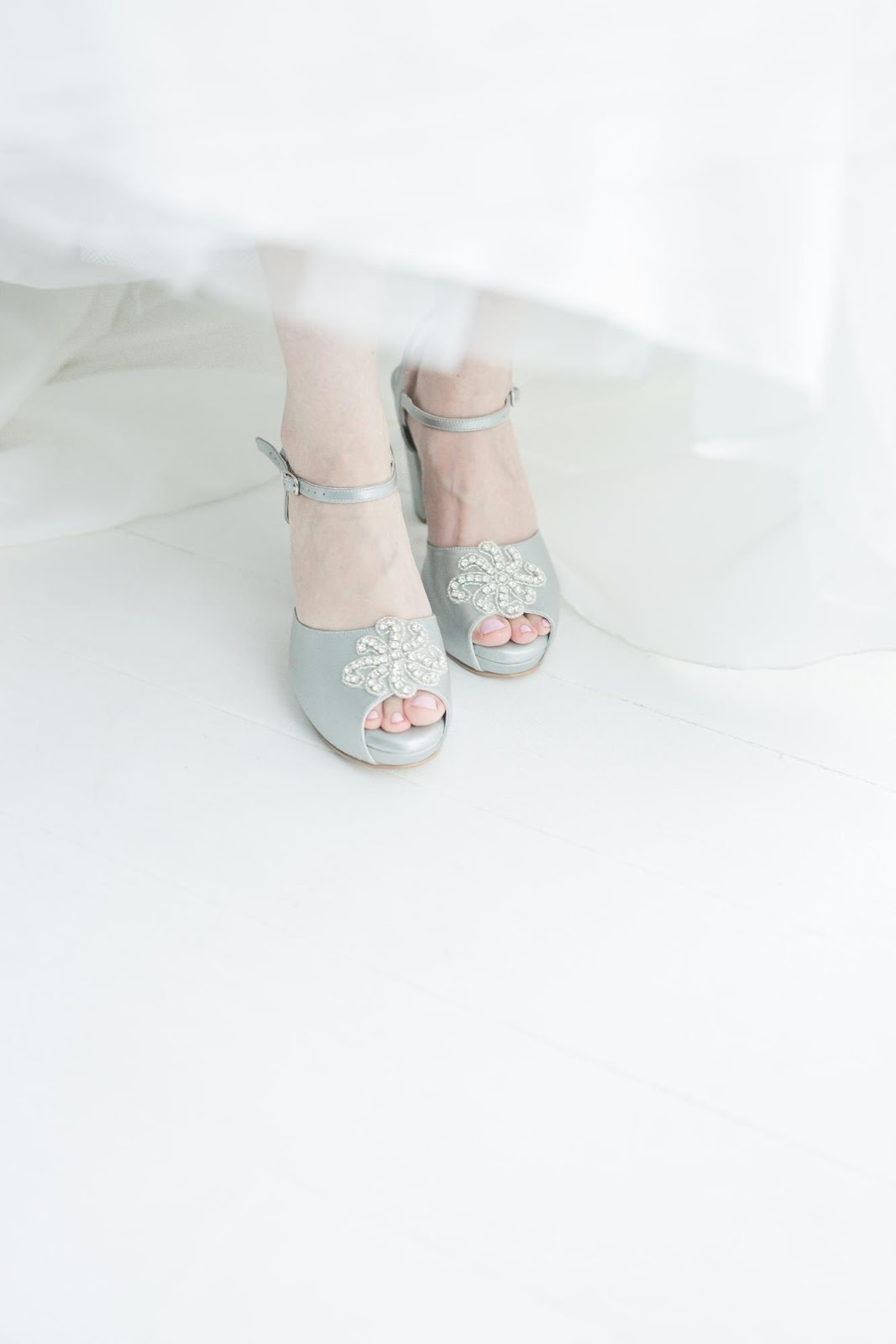 Pair of pastel blue bridal shoes on a seasonal decor backdrop