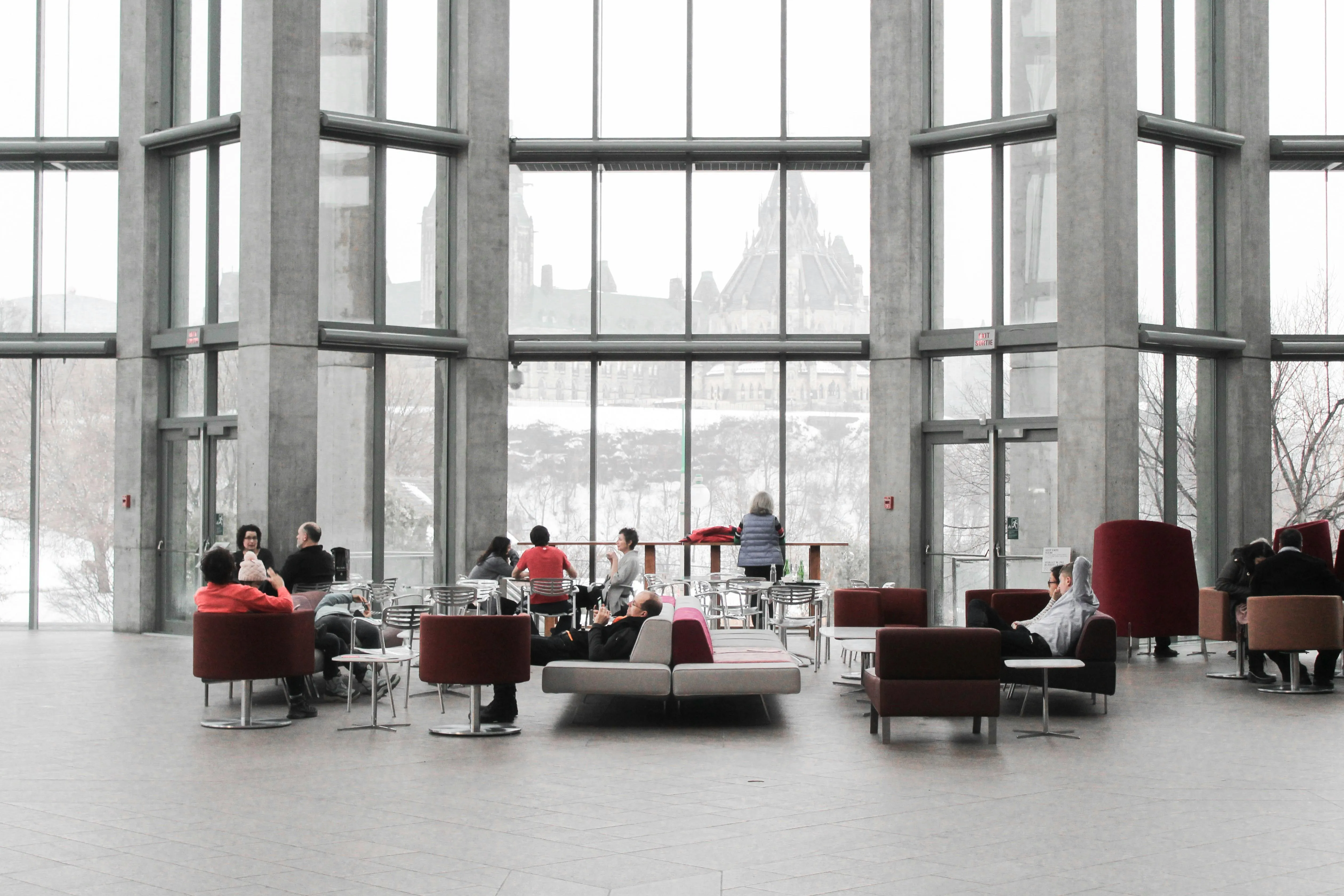 An office lobby with a few people sitting on sofas and chairs
