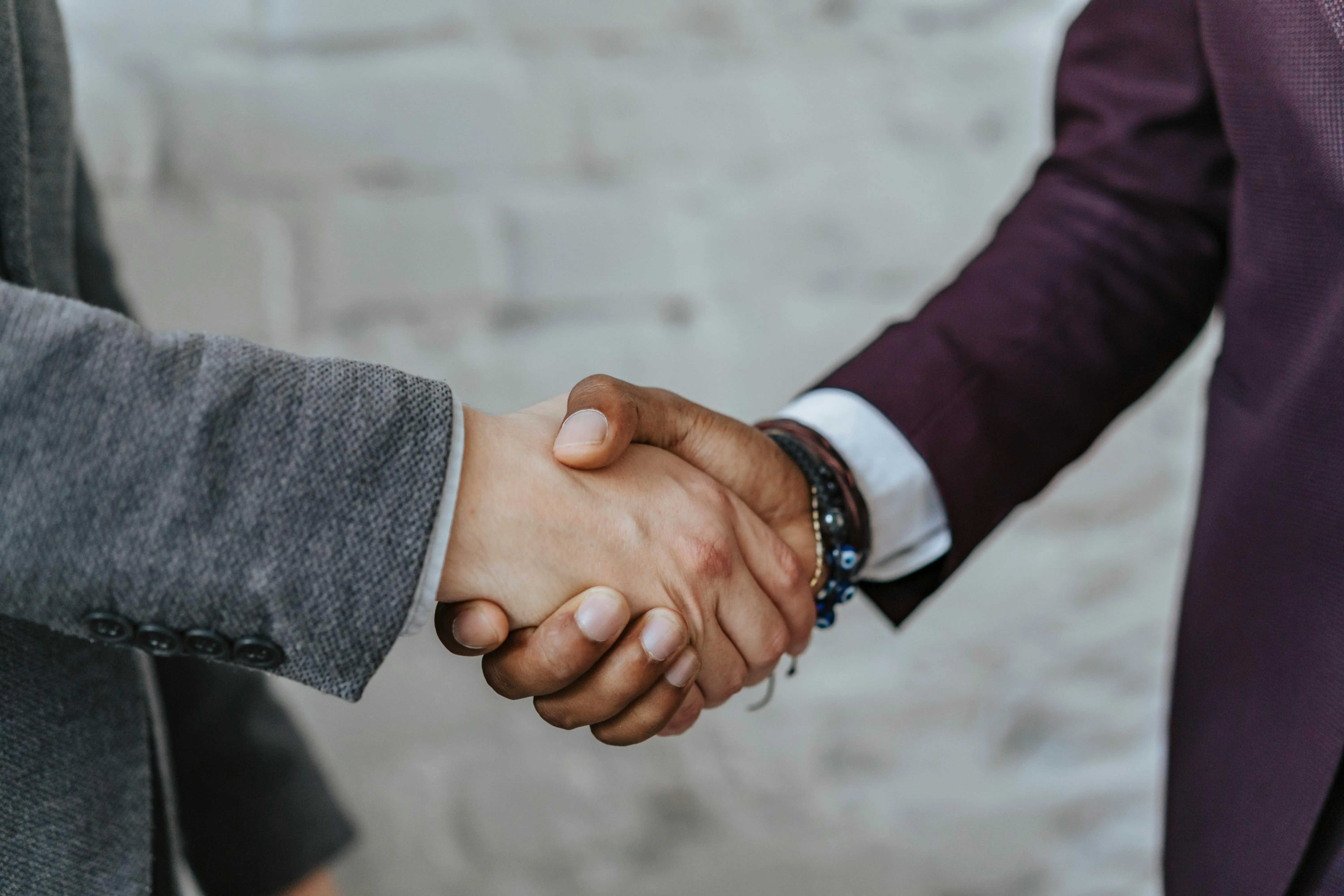 Two men wearing suits, shaking hands