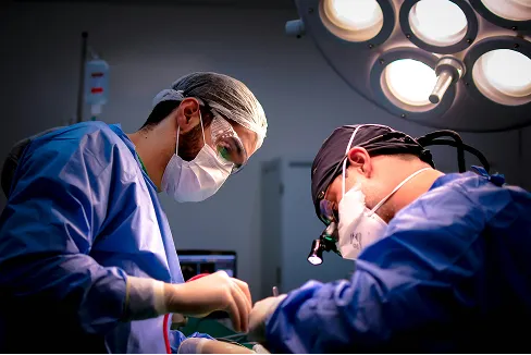 Two doctors operating on someone