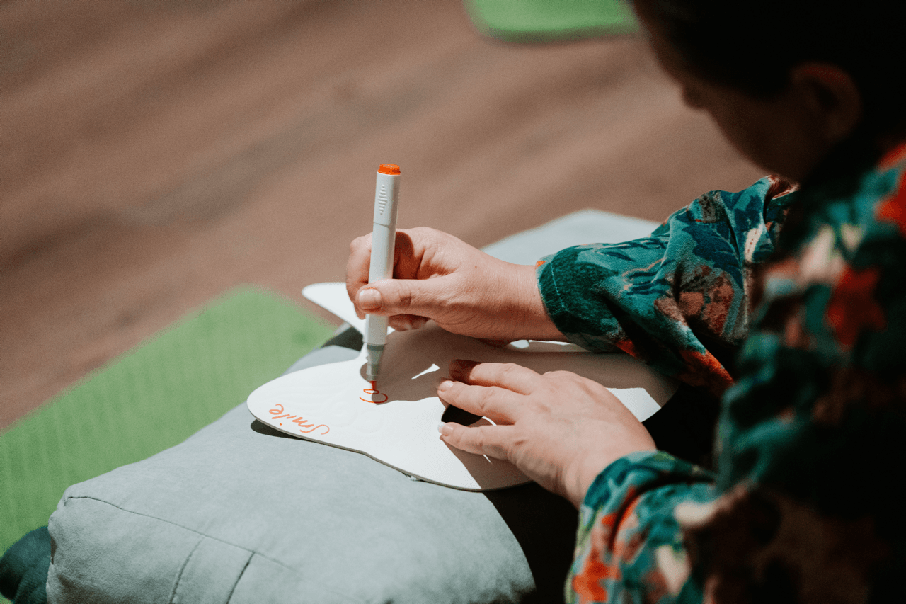 A woman writing with a marker on a paper form during a facilitated session