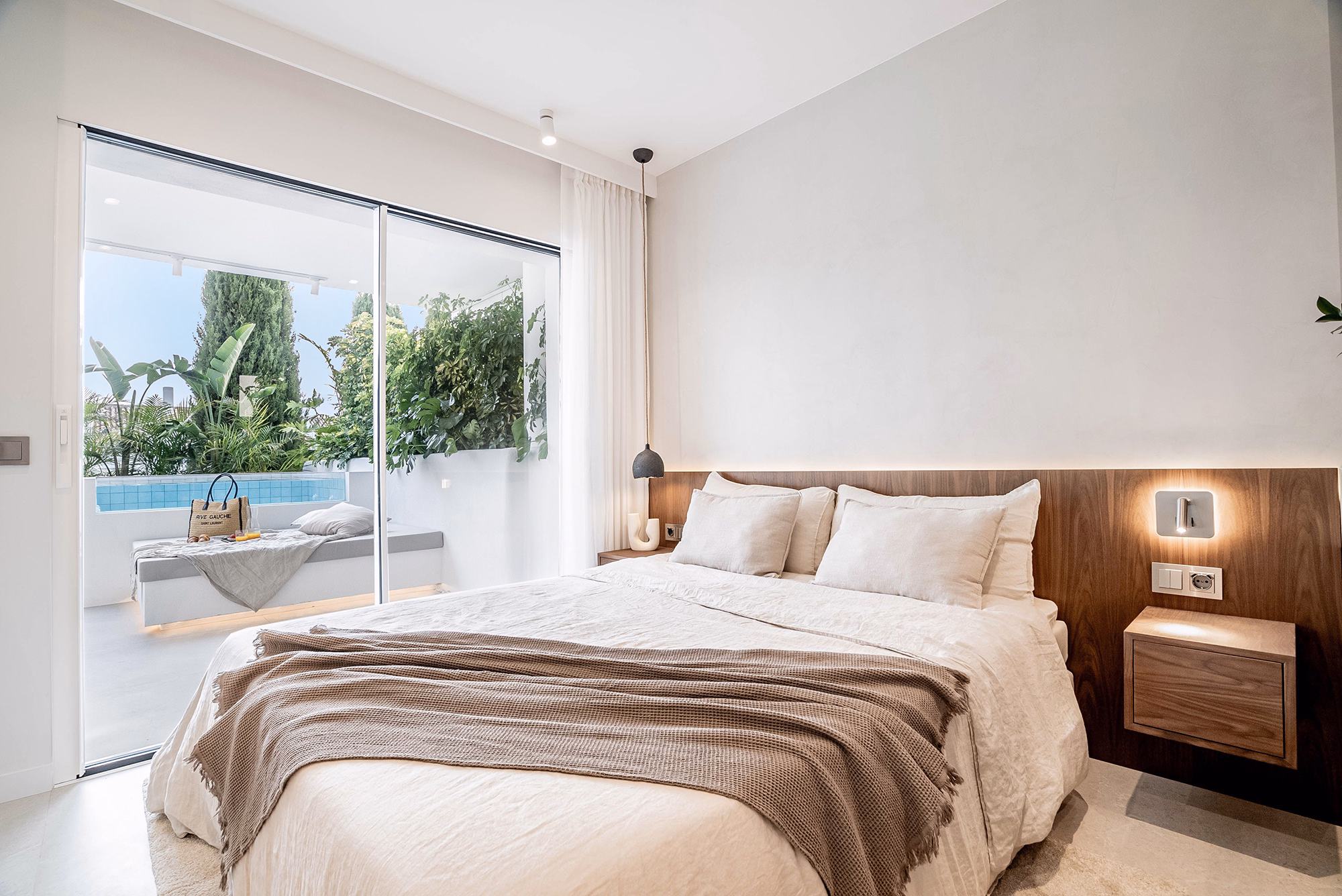 Master bedroom with terrace access and natural decor at Casa Louneh apartment in Aloha, Spain