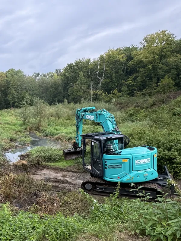 Curage d'un ruisseau par une mini-pelle Kobelco de 8 tonnes avec bras déporté