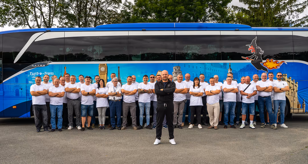 Zespół doświadczonych kierowców firmy Turbo-Trans z właścicielem na czele, stojący przed flagowym autokarem Setra – gwarancja profesjonalizmu i bezpieczeństwa.