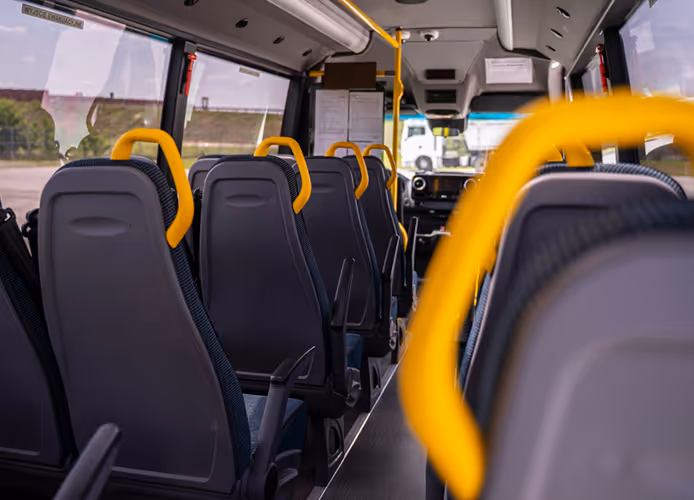 Wnętrze autobusu liniowego Mercedes Sprinter z miejscami siedzącymi i uchwytami dla pasażerów stojących, obsługującego trasy w powiecie wołowskim.
